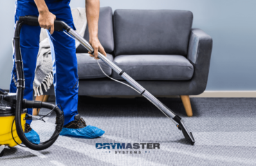 Professional carpet cleaner using single jet DryMaster carpet extractor on commercial carpets.